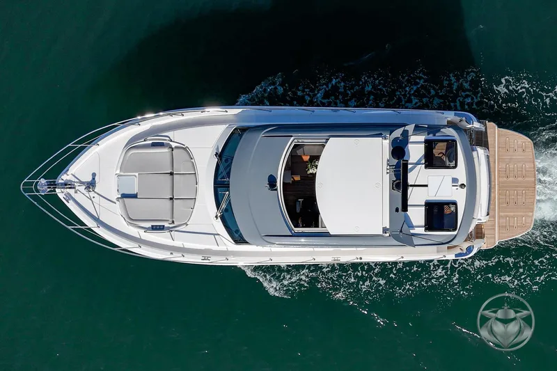 Slide: The Image of Aerial view of 2026 Riviera 4600 Sport Yacht Platinum Edition cruising on water. - 13