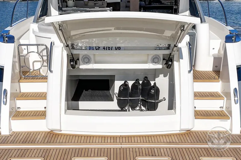 Slide: The Image of 2026 Riviera 4600 Sport Yacht Platinum Edition with open storage compartment and teak deck. - 17