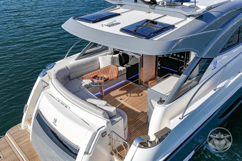 Slide: The Image of 2026 Riviera 4600 Sport Yacht Platinum Edition on water, featuring luxurious deck seating. - 19
