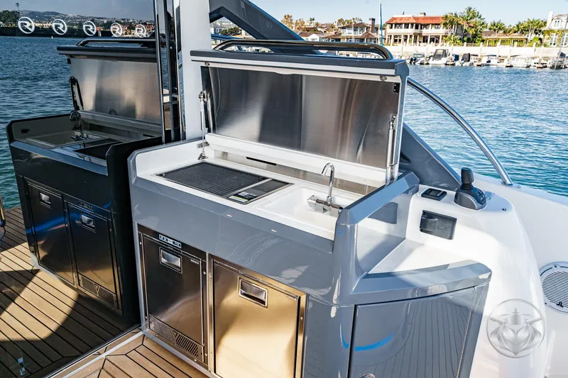 Slide: The Image of Outdoor kitchen on 2026 Riviera 4600 Sport Yacht Platinum Edition, featuring grill and sink. - 25