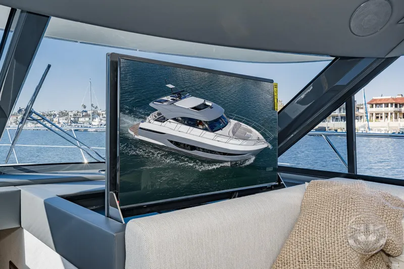 Slide: The Image of 2026 Riviera 4600 Sport Yacht Platinum Edition interior with TV displaying yacht image. - 35