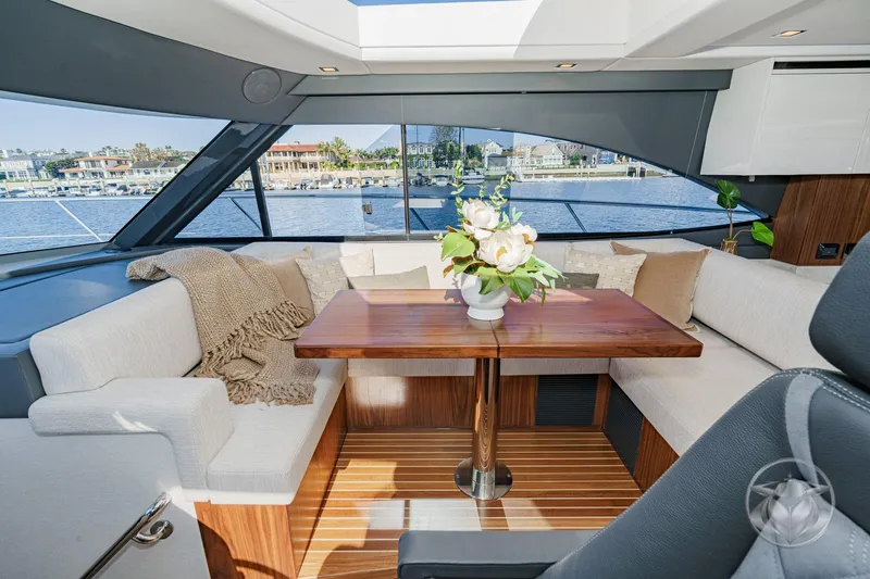 Slide: The Image of Luxurious interior of 2026 Riviera 4600 Sport Yacht Platinum Edition with elegant seating and floral centerpiece. - 36