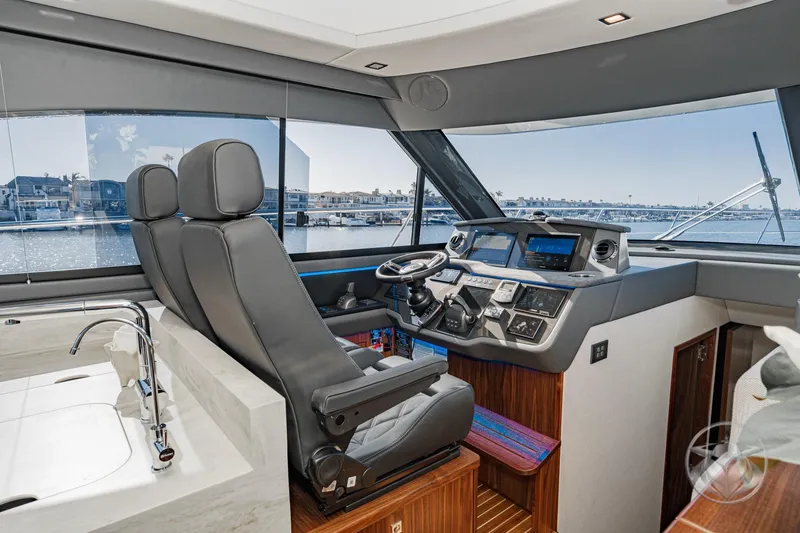 Slide: The Image of Interior of 2026 Riviera 4600 Sport Yacht Platinum Edition, featuring modern helm and luxurious seating. - 38