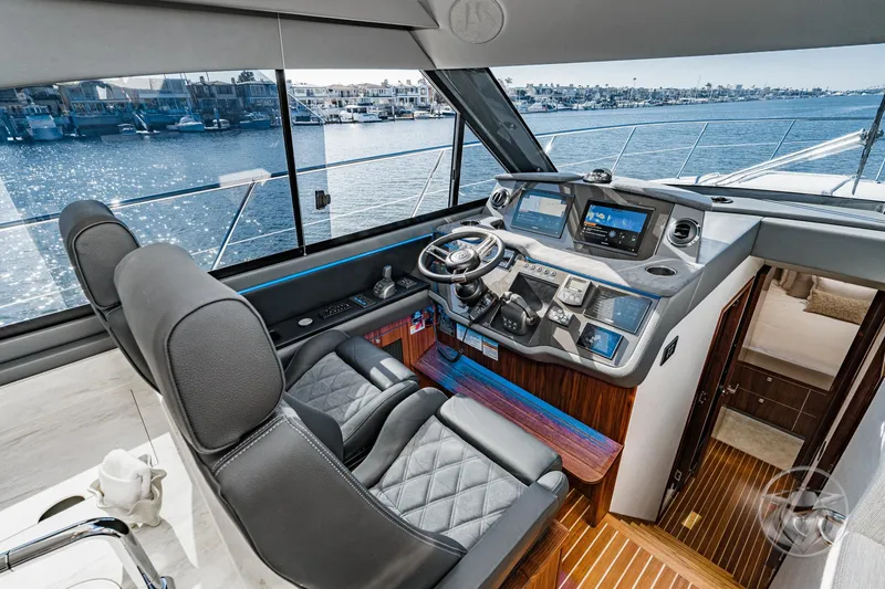Slide: The Image of Interior of 2026 Riviera 4600 Sport Yacht Platinum Edition, featuring luxurious helm and waterfront view. - 39