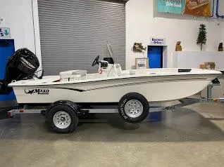 Slide: The Image of 2023 Mako Pro Skiff 15 CC boat on trailer in indoor showroom. - 0