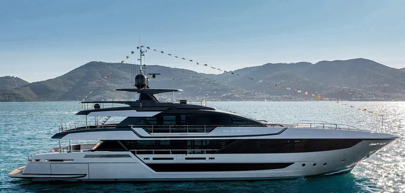 Slide: The Image of 2023 Riva 130' BELLISSIMA luxury yacht on the water with scenic mountain backdrop. - 0