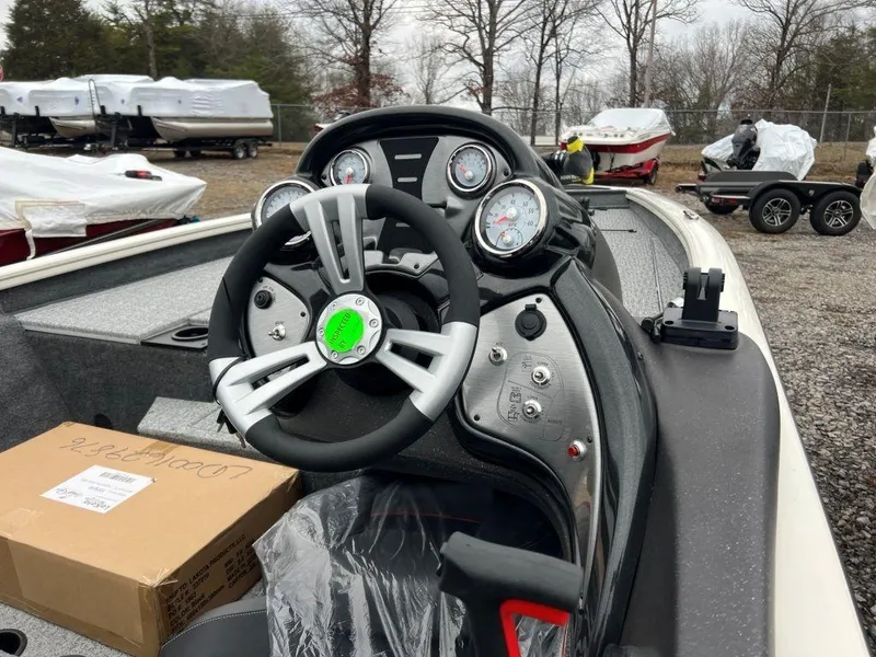Slide: The Image of 2023 Tracker Pro Team™ 190 TX boat dashboard and steering wheel in outdoor setting. - 2