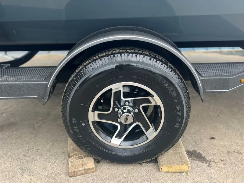 Slide: The Image of 2023 Ranger RT188P trailer wheel on wooden blocks, featuring sleek alloy rims. - 2