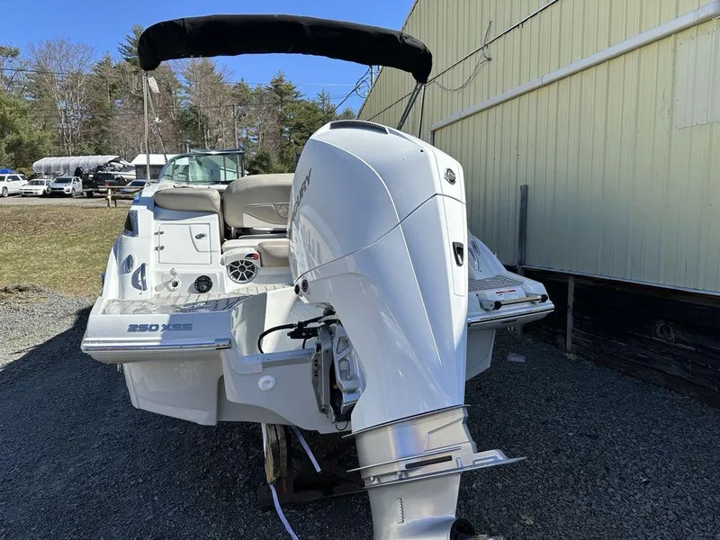 Slide: The Image of 2024 Crownline XSS Series 250 boat with outboard motor, docked outdoors. - 4