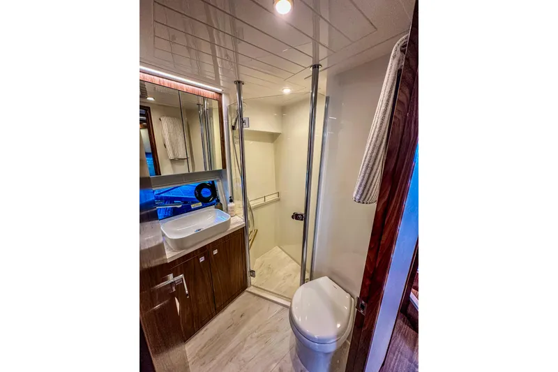 Slide: The Image of 2026 Riviera 505 SUV yacht with spacious deck and modern interior, docked by scenic waterfront. - 17