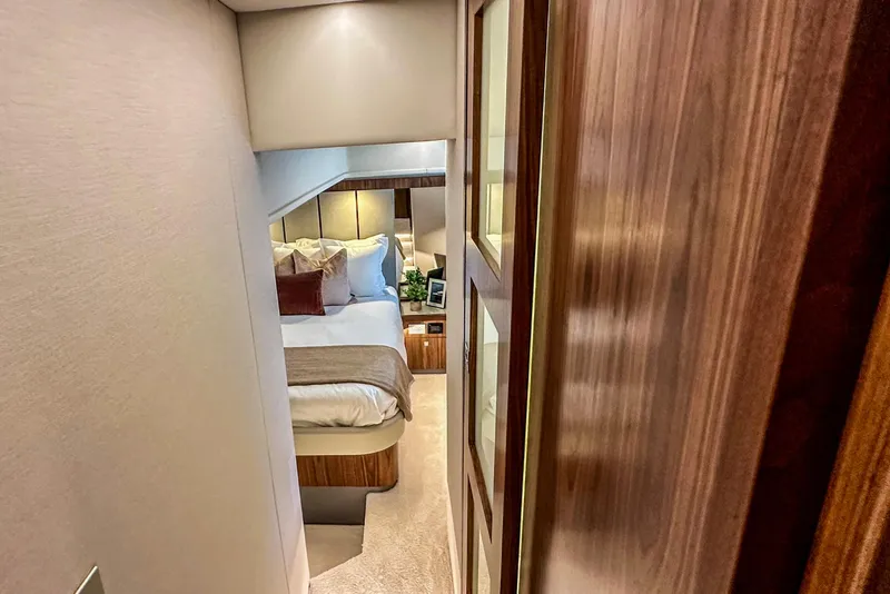 Slide: The Image of Riviera 505 SUV 2026 yacht deck with storage compartment, overlooking water. - 19