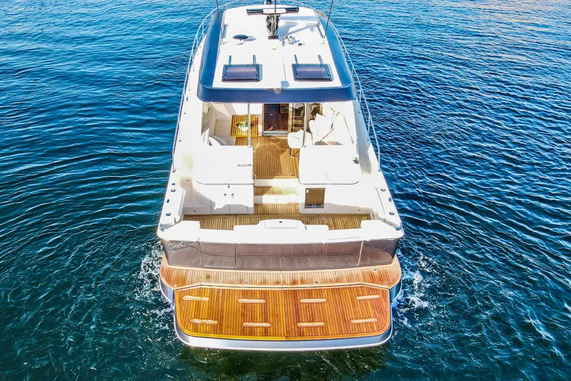 Slide: The Image of 2026 Riviera 505 SUV luxury yacht on calm blue water, showcasing sleek design and spacious deck. - 4