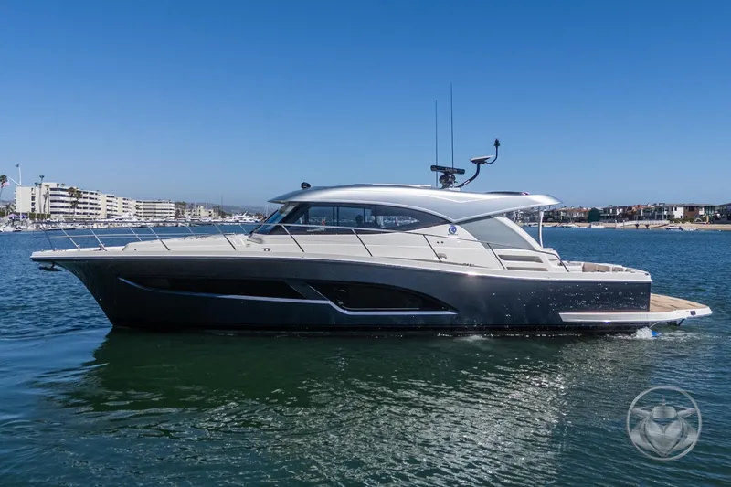 The Image of 2025 Riviera 465 SUV yacht cruising on calm waters under clear blue skies. - 0