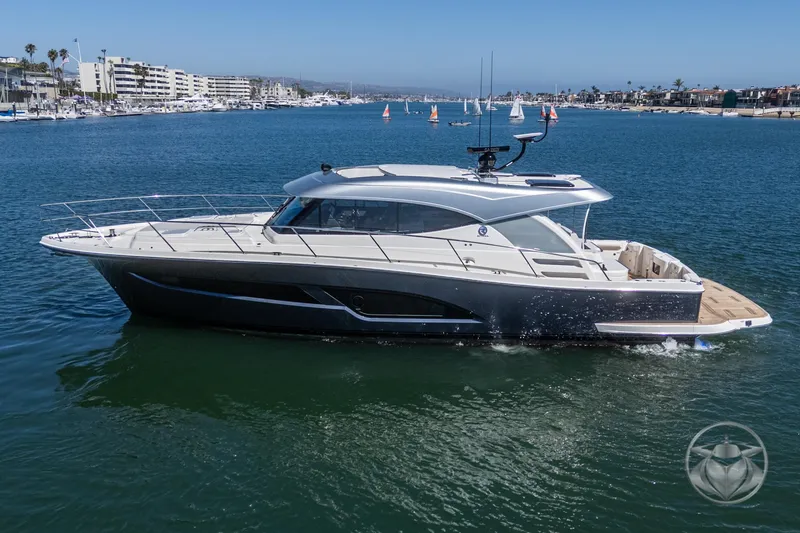 Slide: The Image of 2025 Riviera 465 SUV yacht cruising in a marina with sailboats in the background. - 10