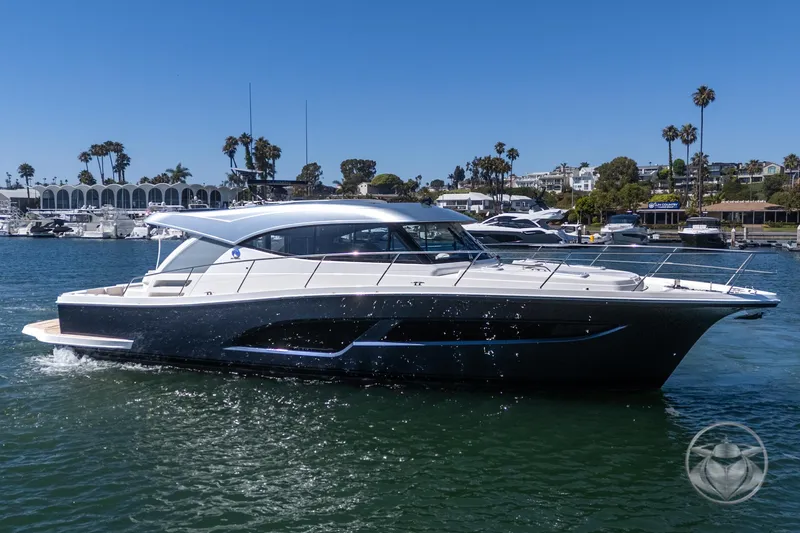 Slide: The Image of 2025 Riviera 465 SUV yacht cruising in a sunny marina, surrounded by palm trees and luxury boats. - 13