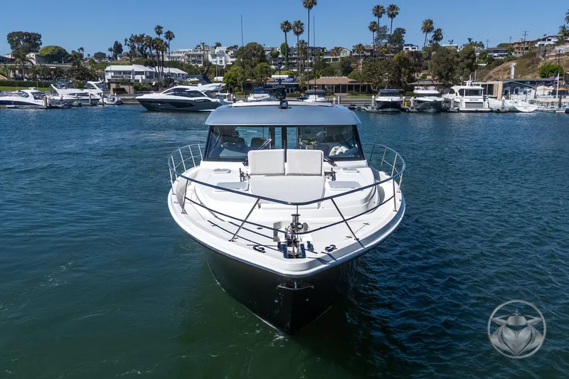 Slide: The Image of 2025 Riviera 465 SUV yacht docked in a marina, surrounded by other boats. - 18