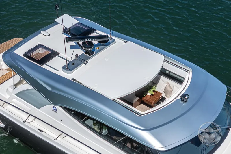 Slide: The Image of 2025 Riviera 465 SUV yacht with sleek design and rooftop seating on the water. - 19