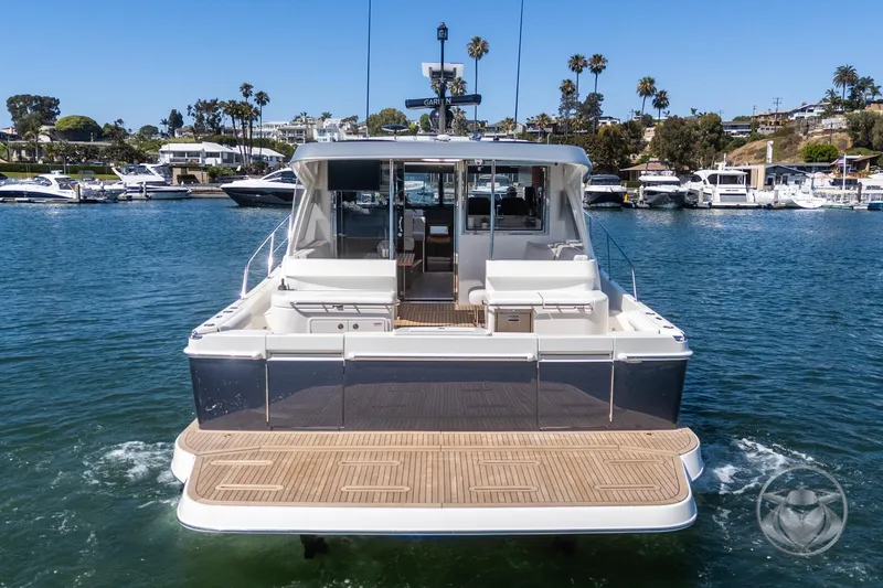 Slide: The Image of 2025 Riviera 465 SUV yacht on water, rear view, docked in marina. - 25