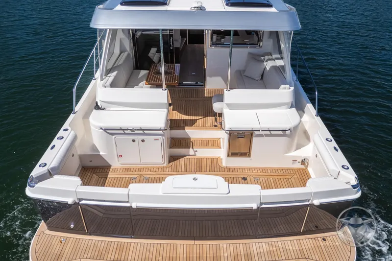 Slide: The Image of 2025 Riviera 465 SUV yacht with spacious deck and luxurious seating on water. - 26