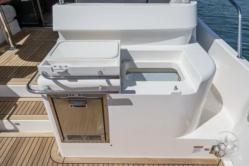 Slide: The Image of Outdoor kitchen area on 2025 Riviera 465 SUV yacht with sink and storage. - 29