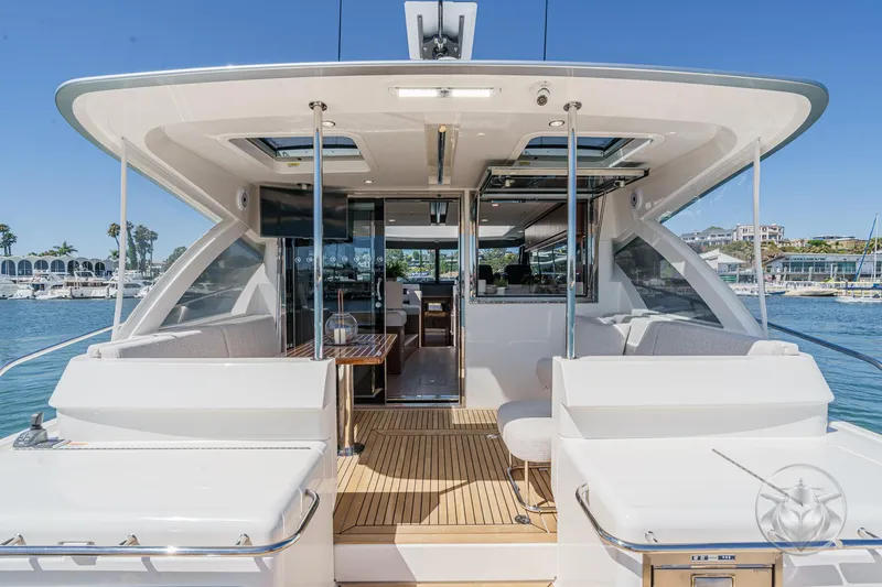 Slide: The Image of 2025 Riviera 465 SUV yacht with spacious deck and luxurious interior, docked at marina. - 3