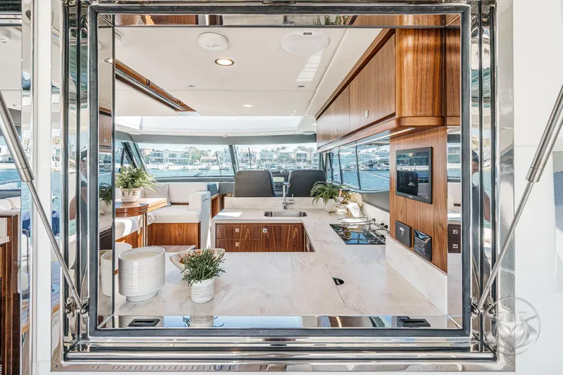 Slide: The Image of Luxurious interior of 2025 Riviera 465 SUV yacht with modern kitchen and elegant wood finishes. - 36