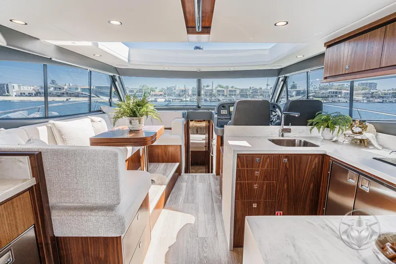 Slide: The Image of Luxurious interior of 2025 Riviera 465 SUV yacht with modern kitchen and panoramic windows. - 4
