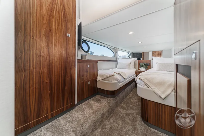 Slide: The Image of Luxurious interior of 2025 Riviera 465 SUV yacht with twin beds and elegant wood finish. - 50