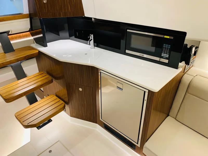 Slide: The Image of 2023 Sea Ray Sundancer 370 OB yacht kitchen with microwave, sink, and wooden steps. - 40