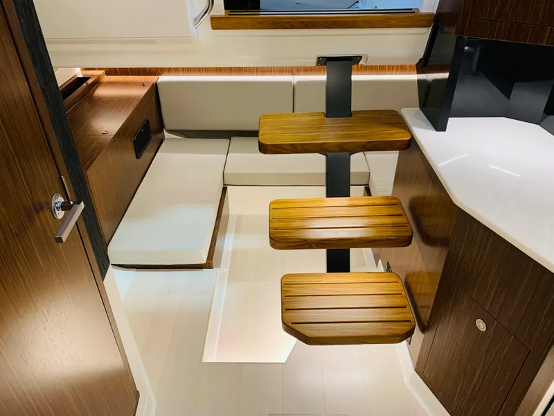 Slide: The Image of 2023 Sea Ray Sundancer 370 OB interior with modern seating and wooden steps. - 41