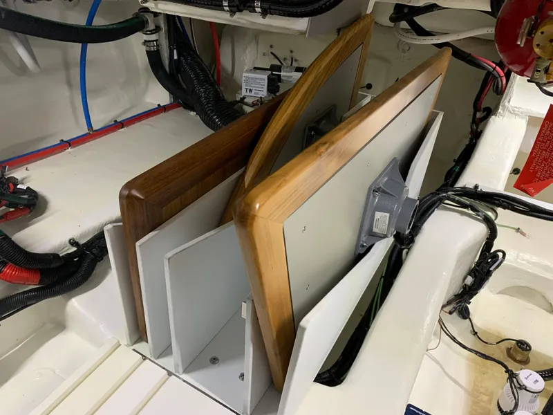 Slide: The Image of 2023 Sea Ray Sundancer 370 OB engine compartment with electrical wiring and wooden panels. - 49