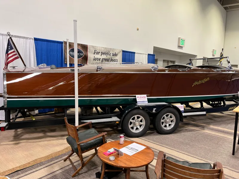 Slide: The Image of 1932 Hacker-Craft Triple Cockpit boat on display with American flag and seating area. - 17