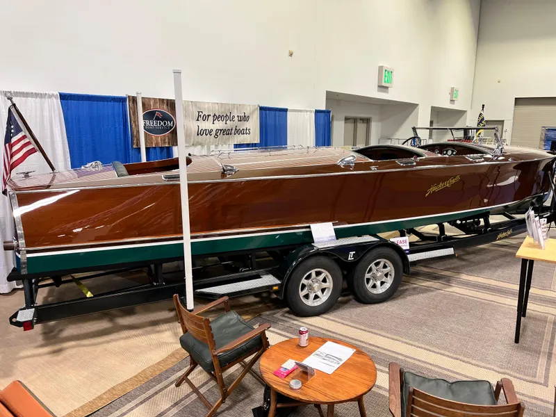 Slide: The Image of 1932 Hacker-Craft Triple Cockpit boat displayed indoors on a trailer. - 18