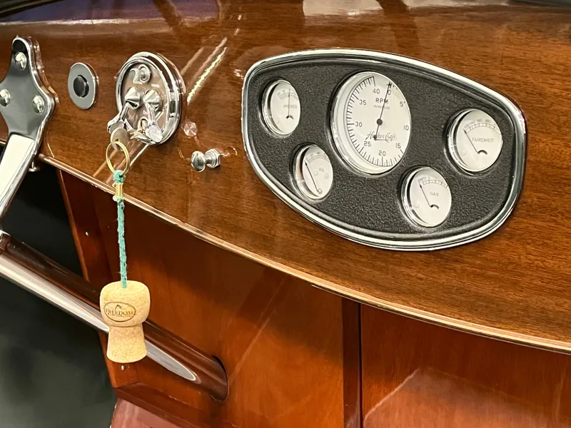 Slide: The Image of 1932 Hacker-Craft Triple Cockpit dashboard with vintage gauges and wooden finish. - 19