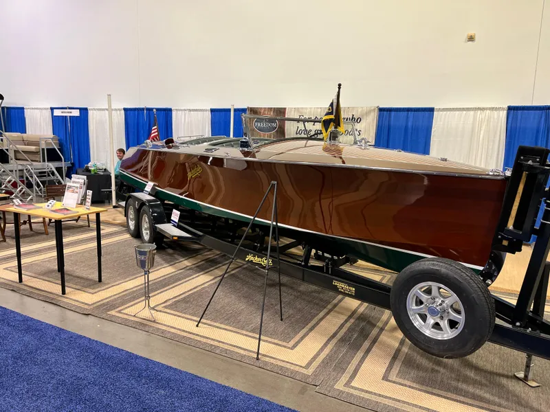 Slide: The Image of 1932 Hacker-Craft Triple Cockpit boat displayed on a trailer at an indoor exhibition. - 6