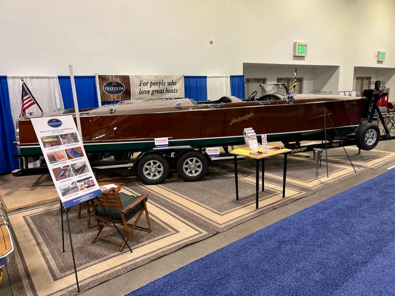 Slide: The Image of 1932 Hacker-Craft Triple Cockpit boat on display with informational signs and seating. - 8