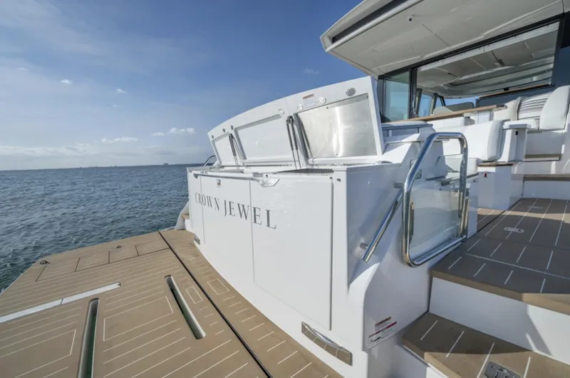 Slide: The Image of 2024 Tiara Yachts EX 60 luxury yacht stern view with deck and stairs. - 19