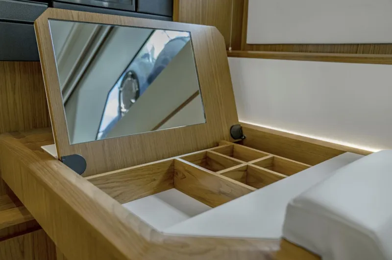 Slide: The Image of 2024 Tiara Yachts EX 60 vanity with mirror and storage compartments. - 42