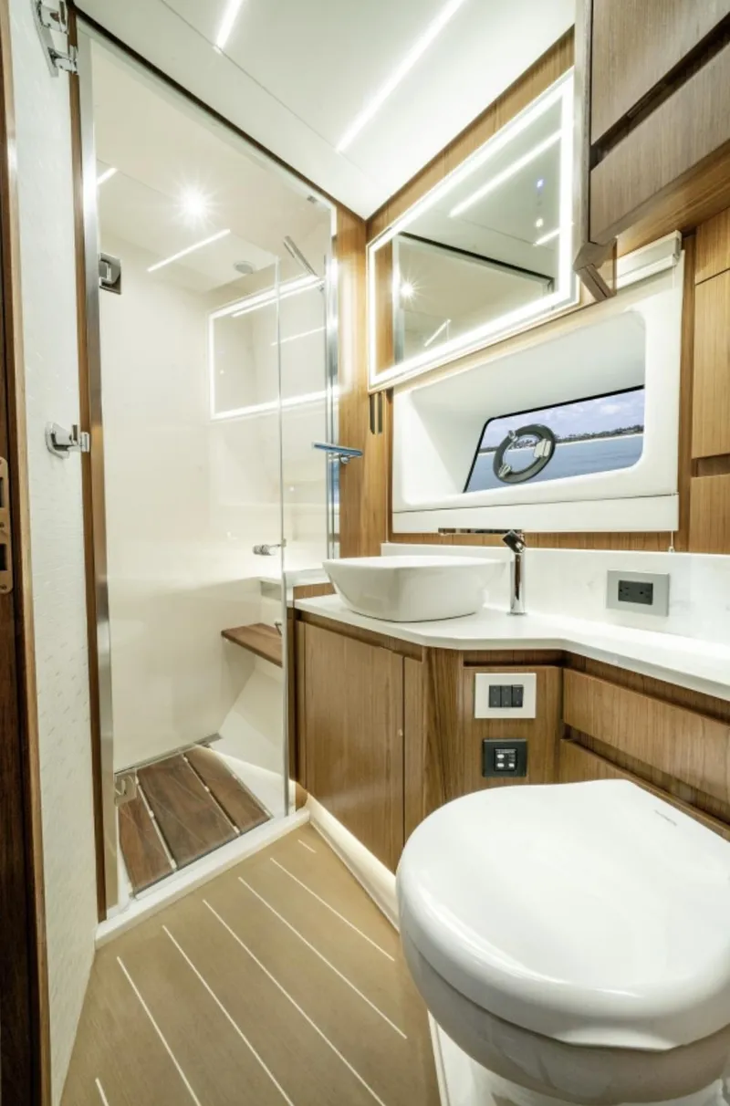 Slide: The Image of 2024 Tiara Yachts EX 60 bathroom with modern fixtures and wooden accents. - 47