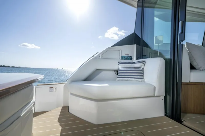 Slide: The Image of 2024 Tiara Yachts EX 60 deck with white seating and ocean view. - 9