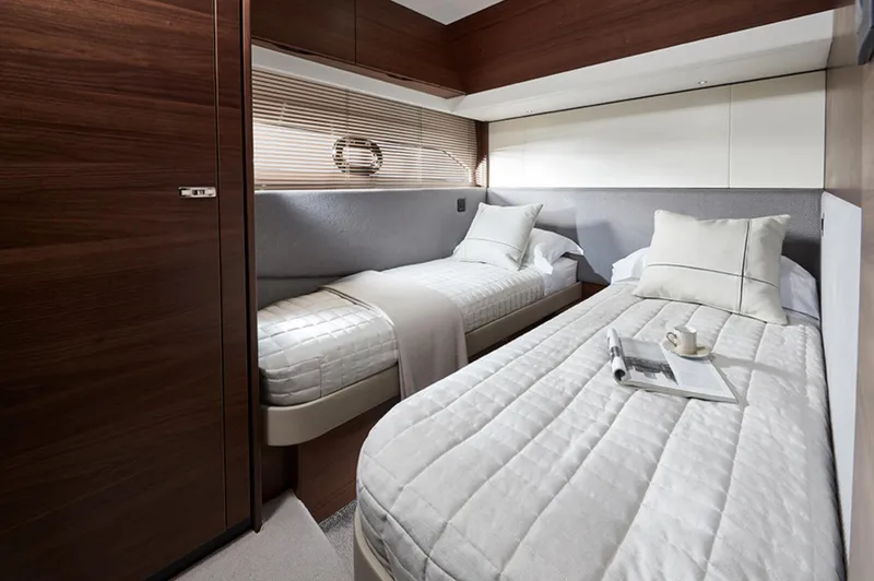 Slide: The Image of Luxurious twin cabin in 2025 Princess F55 yacht with modern decor and cozy bedding. - 39