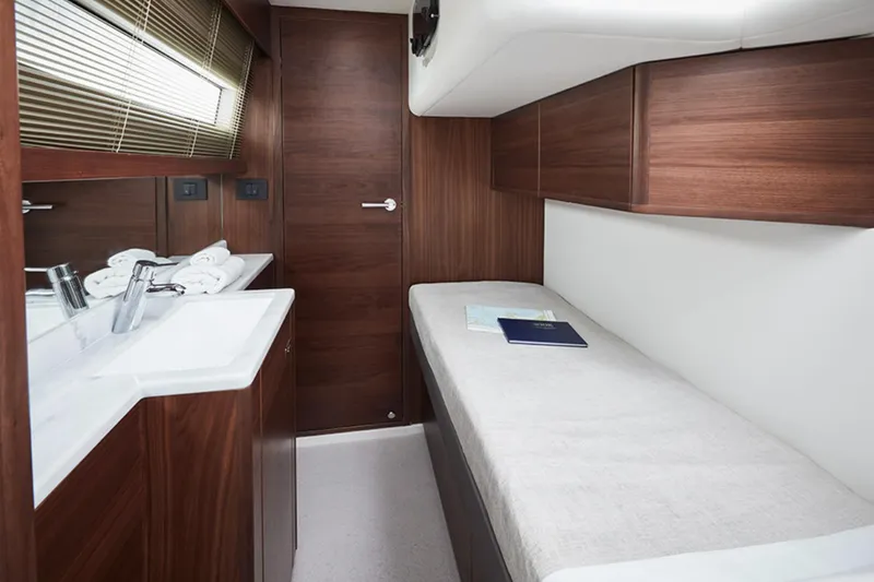 Slide: The Image of 2025 Princess F55 yacht cabin with single bed, wooden cabinetry, and sink. - 40