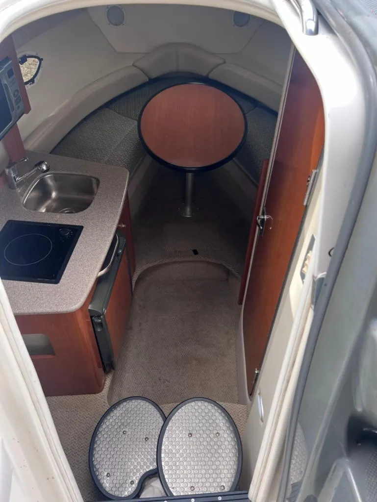 Slide: The Image of Interior cabin of a 2005 Maxum 2500 SCR boat with kitchenette and seating area. - 10