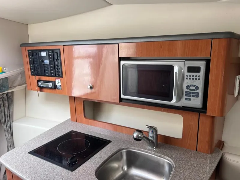 Slide: The Image of 2005 Maxum 2500 SCR boat galley with microwave, sink, and stove. - 11