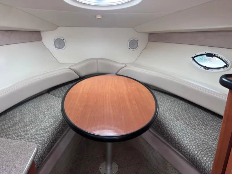 Slide: The Image of Interior of 2005 Maxum 2500 SCR boat with round wooden table and cushioned seating. - 20