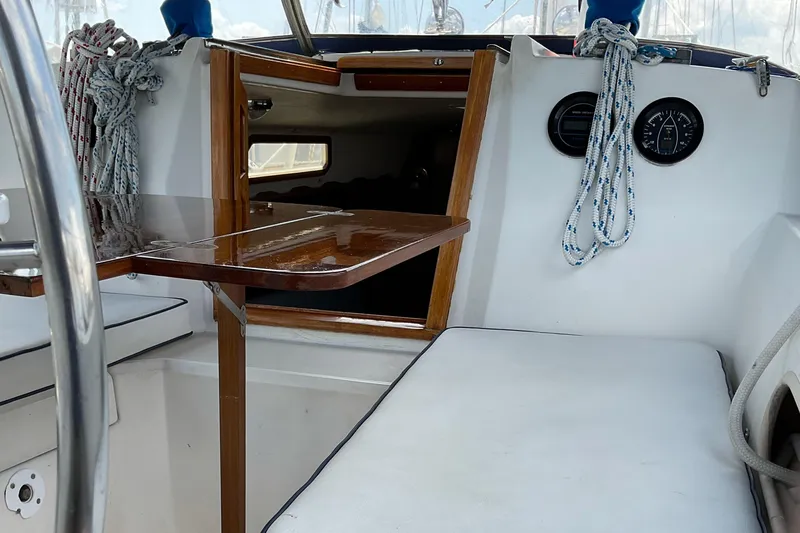 Slide: The Image of Cockpit of 1989 Sabre 34 MK II sailboat with wooden table and white seating. - 14