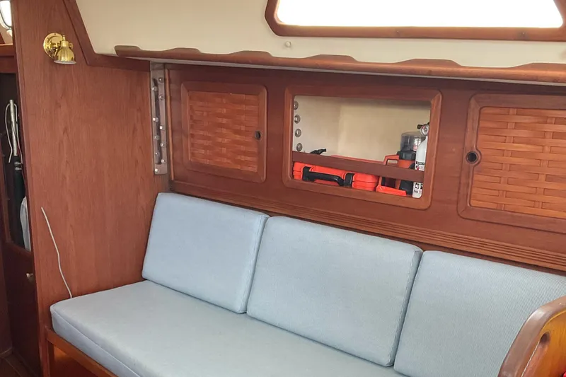 Slide: The Image of Interior of 1989 Sabre 34 MK II sailboat with blue cushioned seating and wooden cabinets. - 22