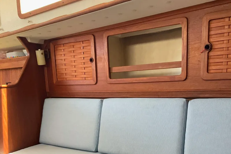 Slide: The Image of 1989 Sabre 34 MK II sailboat interior with wooden cabinets and blue cushions. - 23