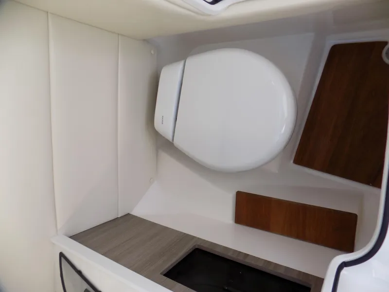 Slide: The Image of 2021 Regal 29 OBX boat interior bathroom with modern toilet and wood accents. - 10