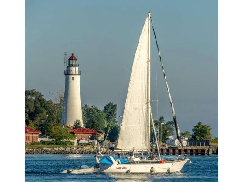The Image of 1980 Kennedy Sloop sailing near a lighthouse on a sunny day. - 0